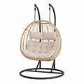 Fauteuil suspendu de jardin 2 places en forme d’œuf en résine tressée PE naturel avec support acier noir 135 x 80 x 200 cm coussins beige